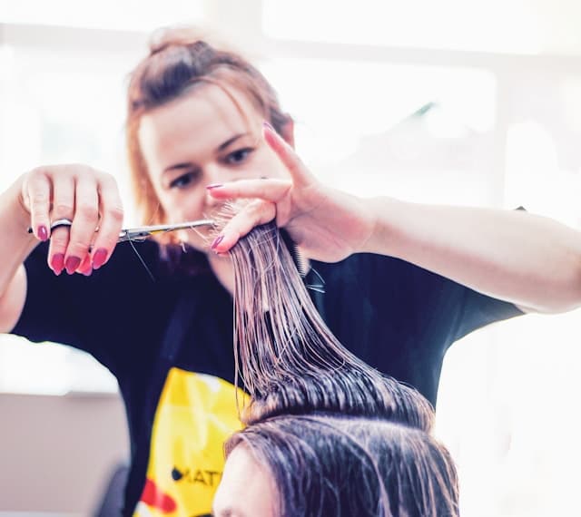 Professional stylist cutting wet hair with precision scissors – expert haircutting service at Merluza Hair & Beauty in Hall Green, Birmingham.