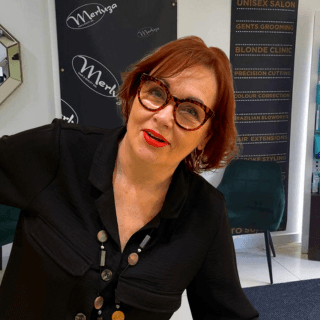 Valerie, founder of Merluza Hair & Beauty in Hall Green, smiling in the salon – expert stylist with decades of experience in cutting and colour.